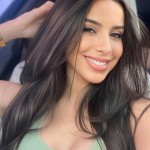 Smiling dark-haired woman in a light green top posing for a selfie.