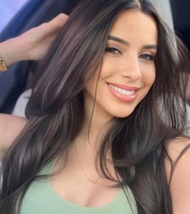Smiling dark-haired woman in a light green top posing for a selfie.